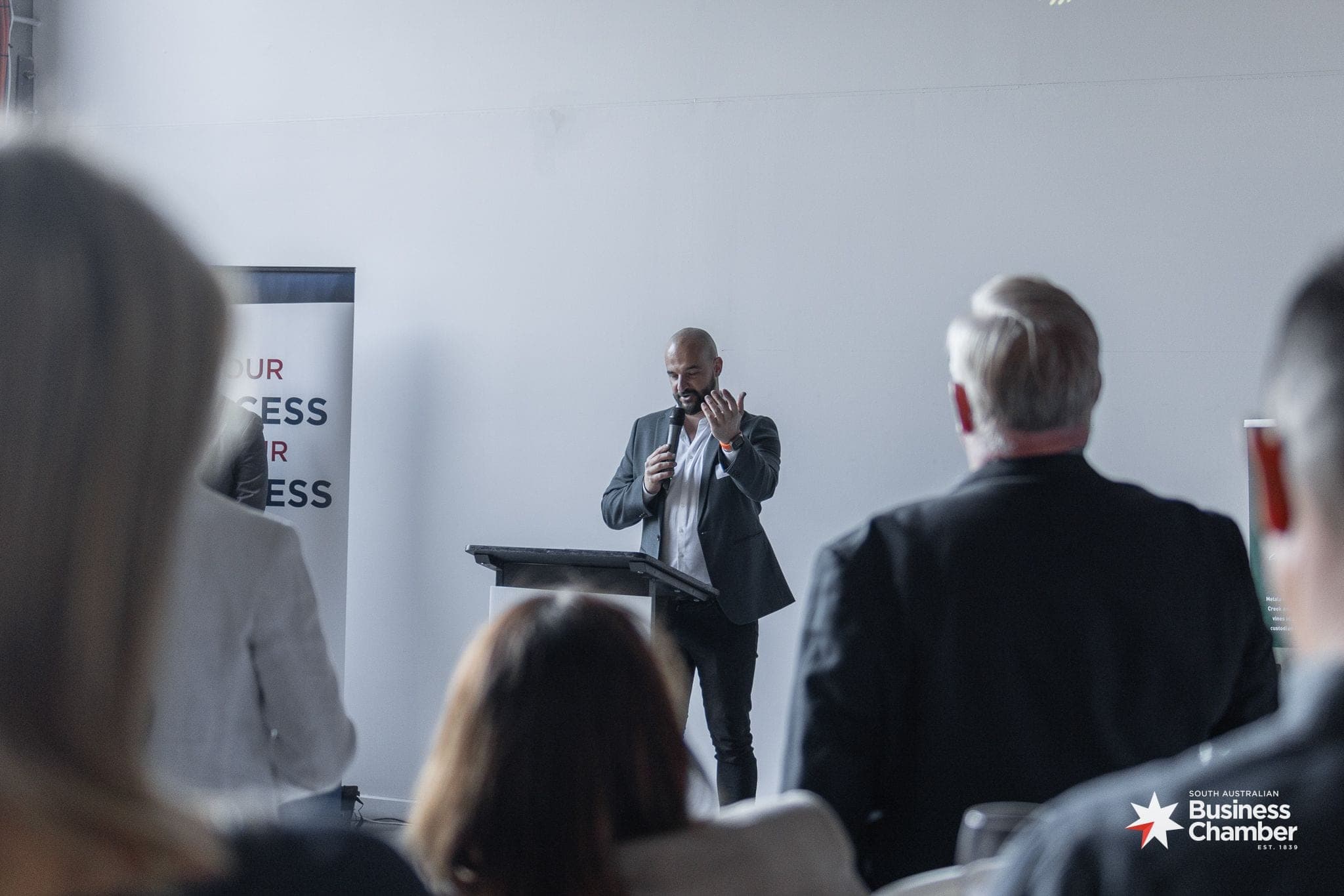 A speaker addressing a seated audience at a South Australian Business Chamber event