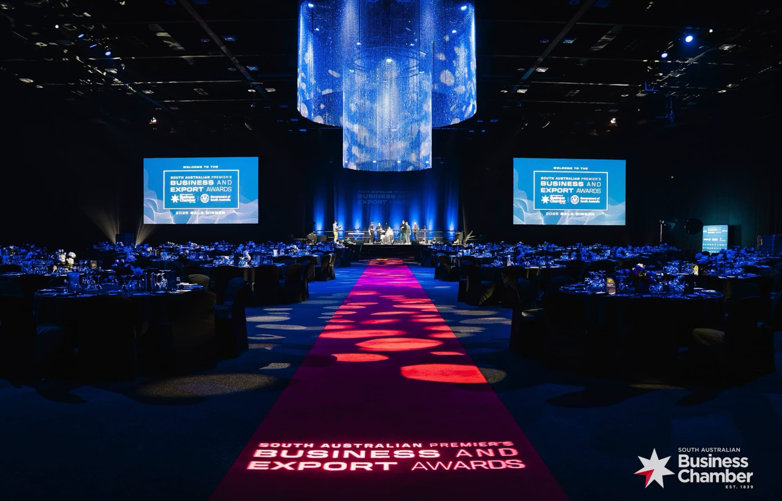 The Business and Export Awards gala room with a lit red carpet, stage and banquet tables