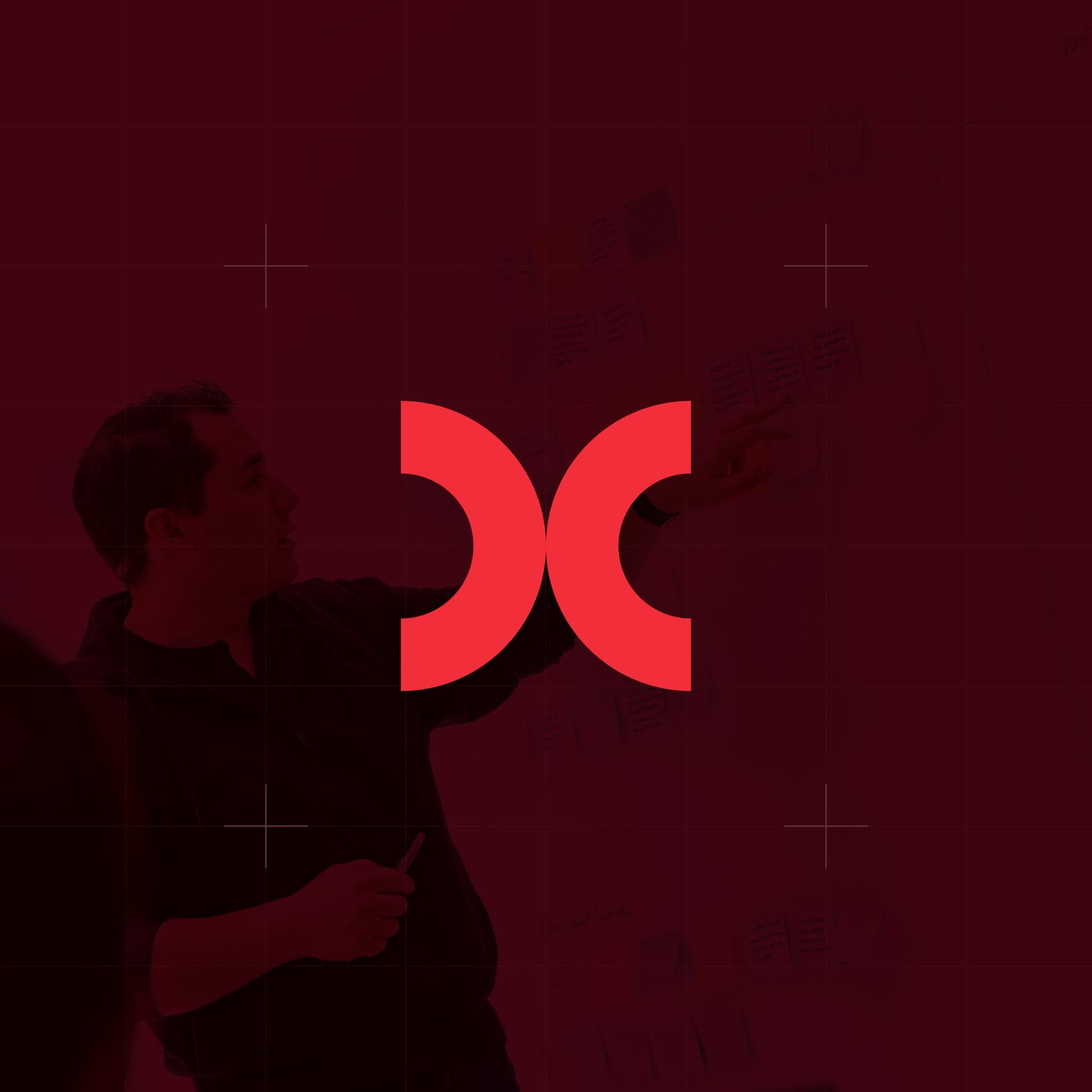 CodeFish Studio double-crescent glyph over a red-tinted photo of a workshop wall session
