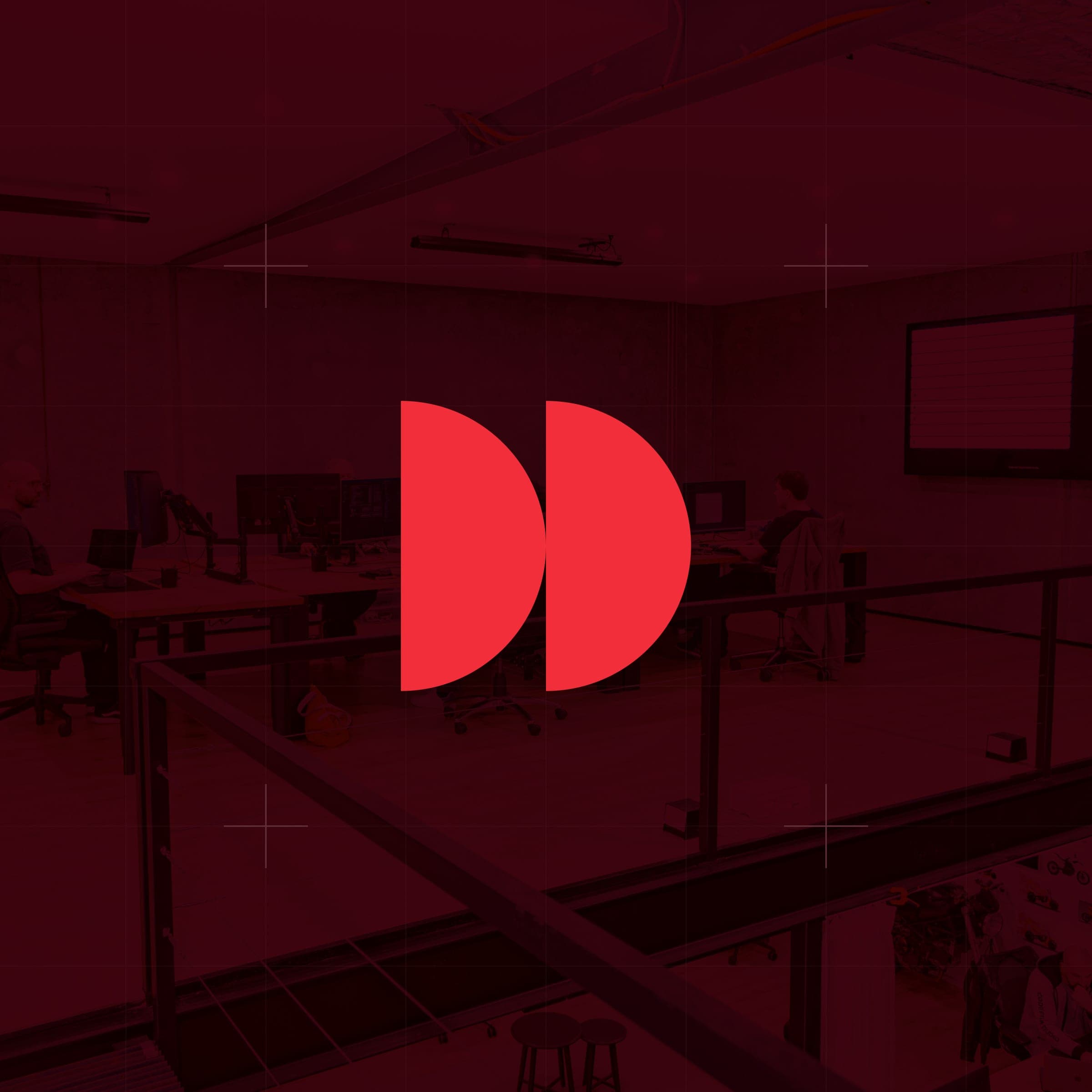 CodeFish Studio twin half-disc glyph over a red-tinted photo of the studio work floor