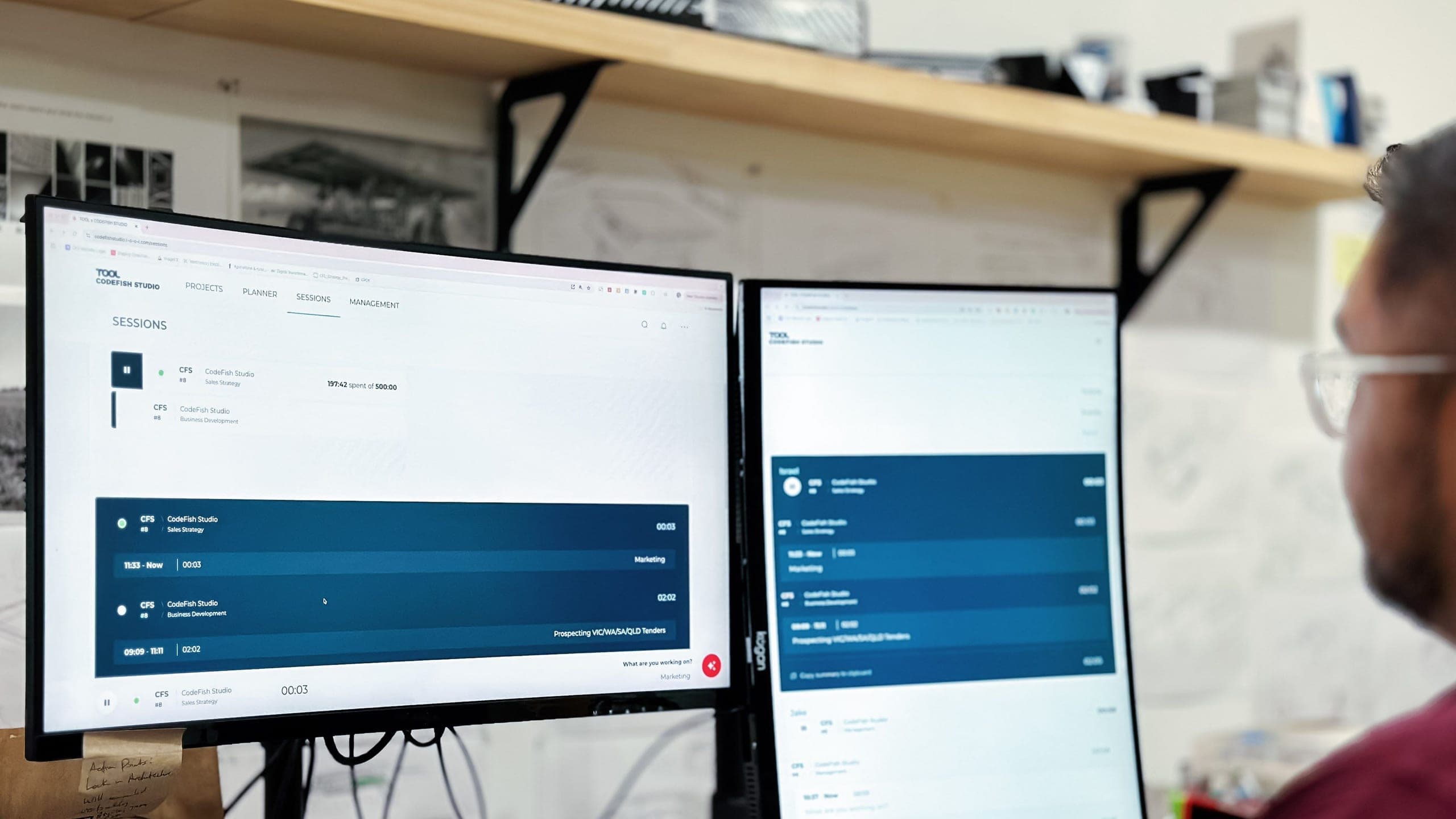 Person looking at two monitors showing a time-tracking web app