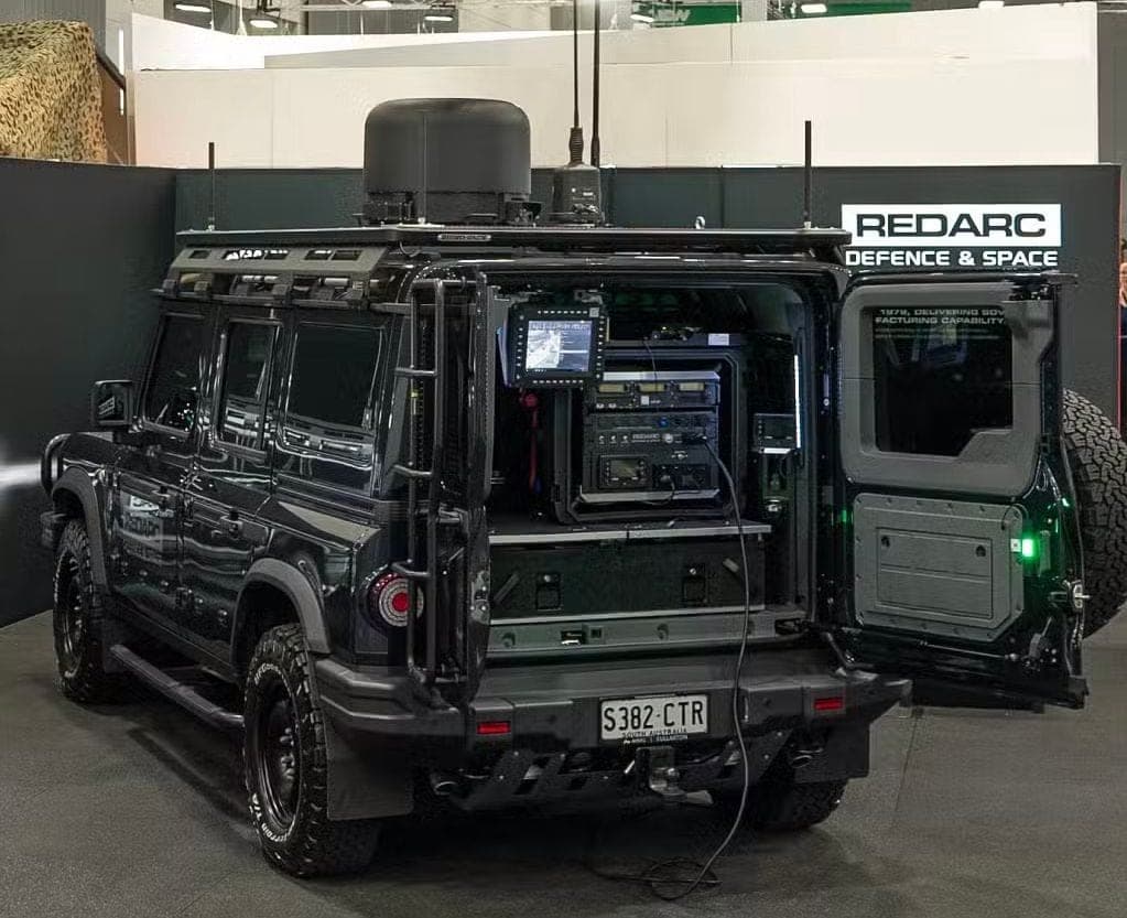 Black INEOS Grenadier fitted with rack-mounted comms gear on a REDARC Defence and Space stand